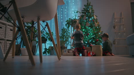 Two-boys-decorate-the-Christmas-tree-at-home.-High-quality-4k-footage